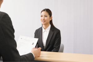 Job applicant in interview while employer reviews her resume and credit history